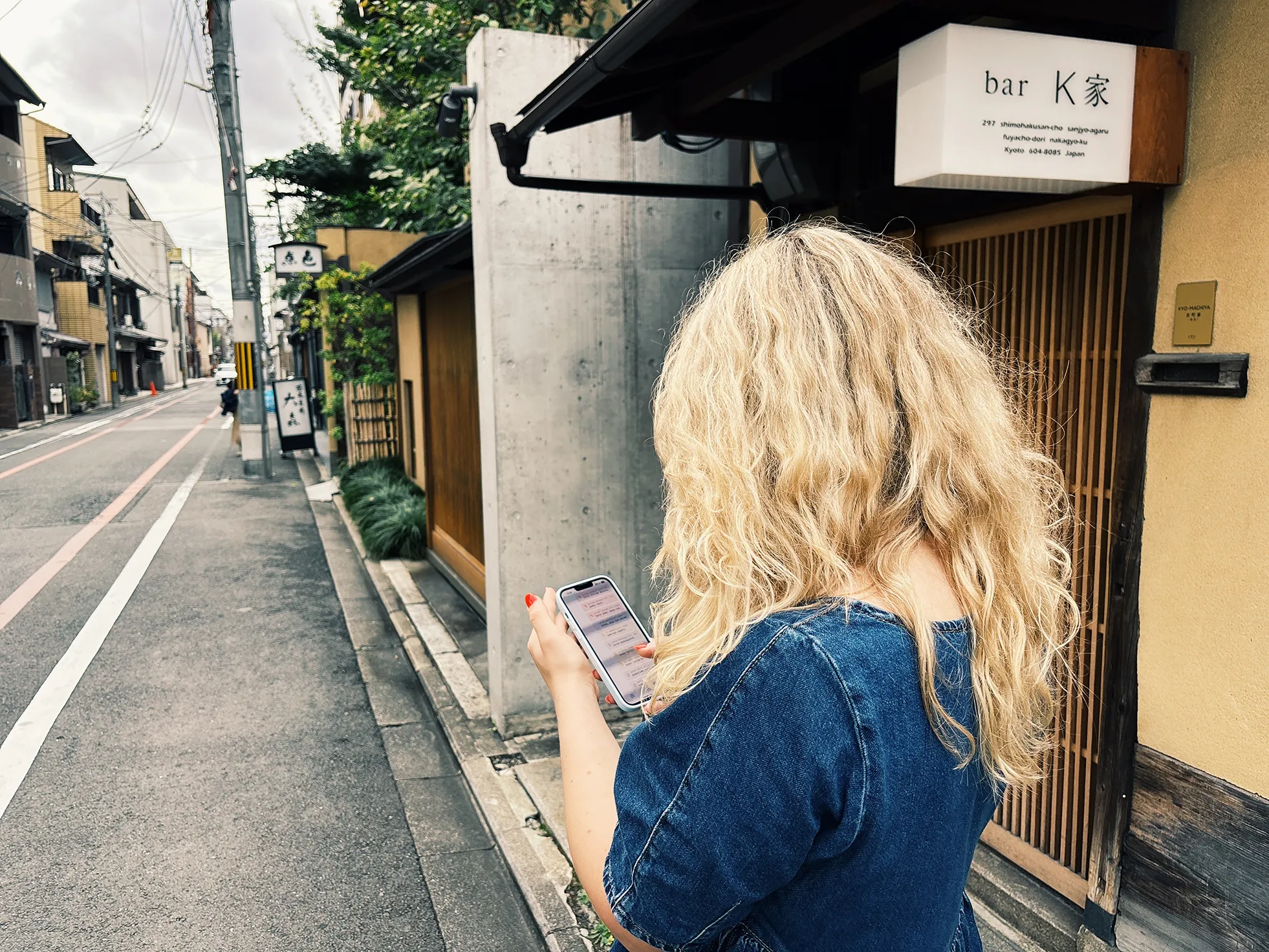 A woman using Plot outside a bar in Kyoto